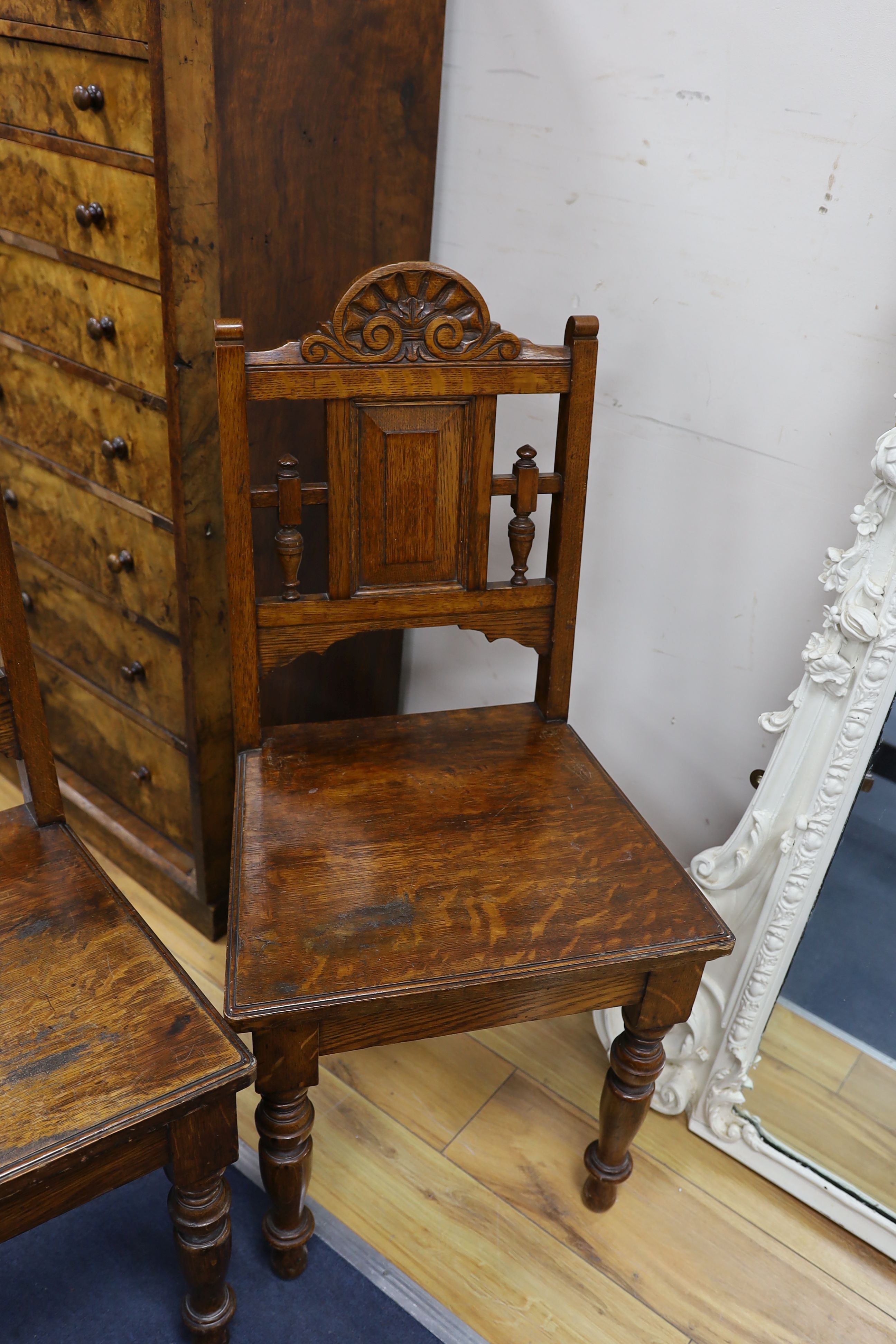 A pair of Victorian carved oak hall chairs